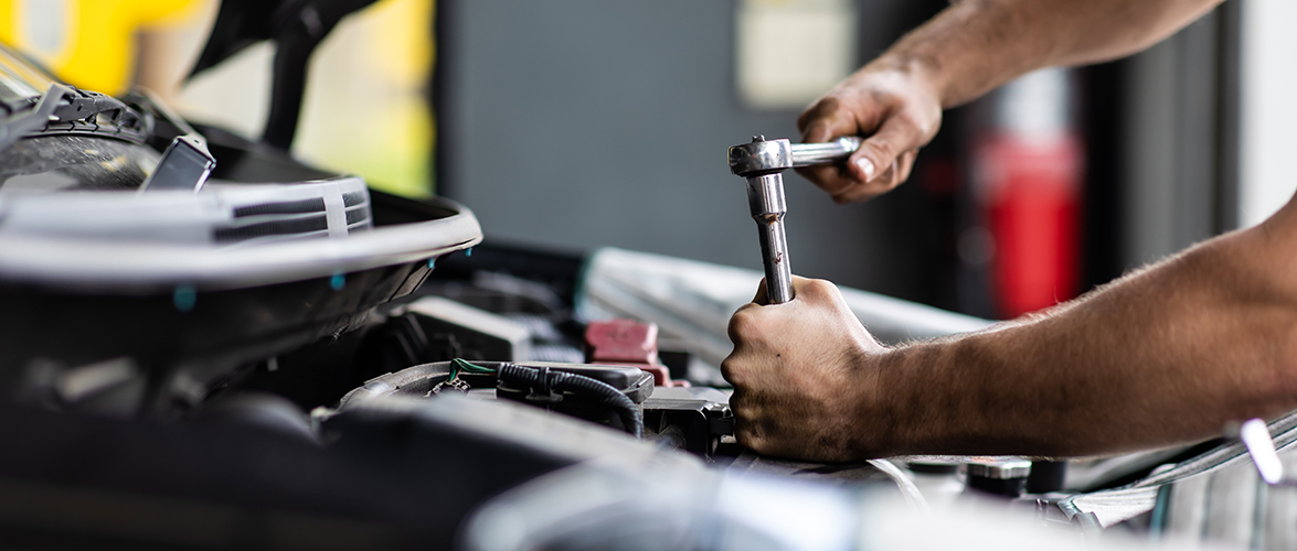 male mechanic repairs car in garage.